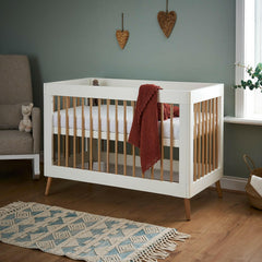 Obaby Maya Mini Cot Bed (White with Natural) - lifestyle image, shown here as the cot bed (mattress and bedding not included, available separately)