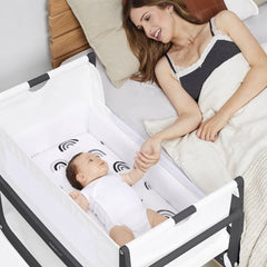 SnuzPod⁴ Bedside Crib 3-in-1 (Slate) - lifestyle image, showing the crib positioned next to parent`s bed