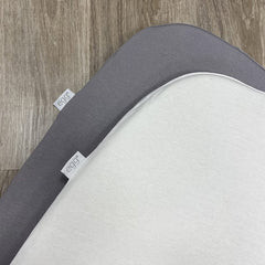 egg2 Carrycot Fitted Sheets - Pack of 2 (Ivory Grey) - showing each sheet fitted to a mattress with their egg branding (mattresses not included)