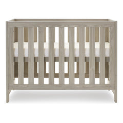 Obaby Nika Cot Bed (Grey Wash) - side view, shown here with the cot`s mattress base at its highest level (mattress not included, available separately)