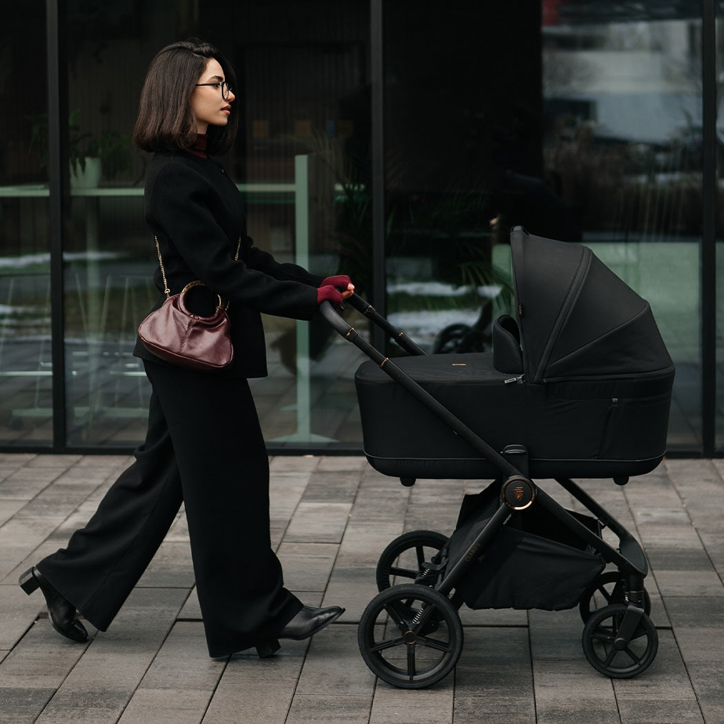 Venicci Claro 2 pram in Noir used outdoors in lifestyle setting