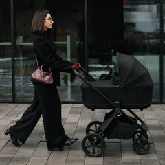 Venicci Claro 2 pram in Noir used outdoors in lifestyle setting