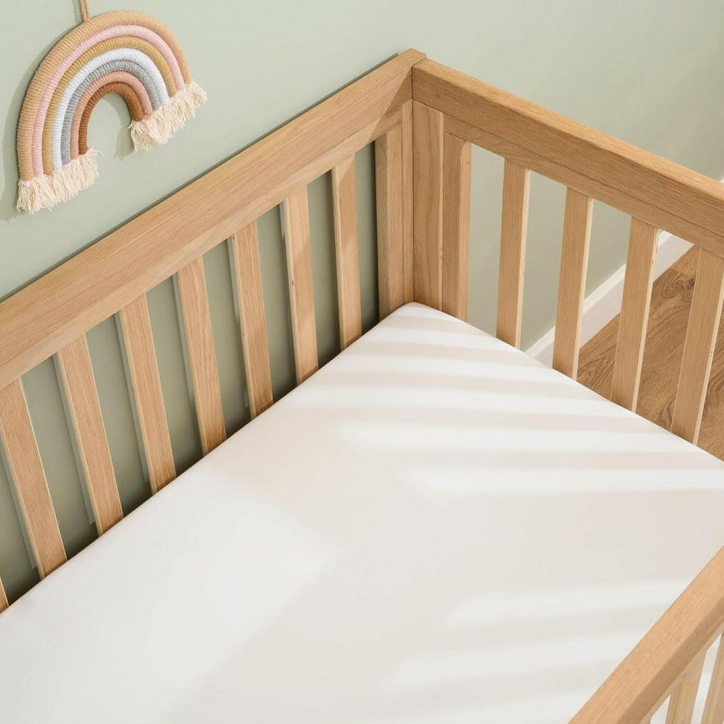 Clair De Lune Fitted Cot Bed Sheets (Pack of 2) - White - showing a sheet fitted to a cot bed mattress