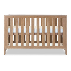 Obaby Nika Cot Bed - Oak - side view, mattress base at highest level