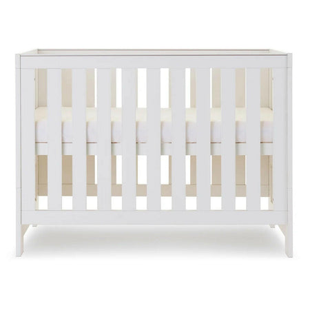 Obaby Nika MINI Cot Bed - White Wash side view, showing mattress base at highest level