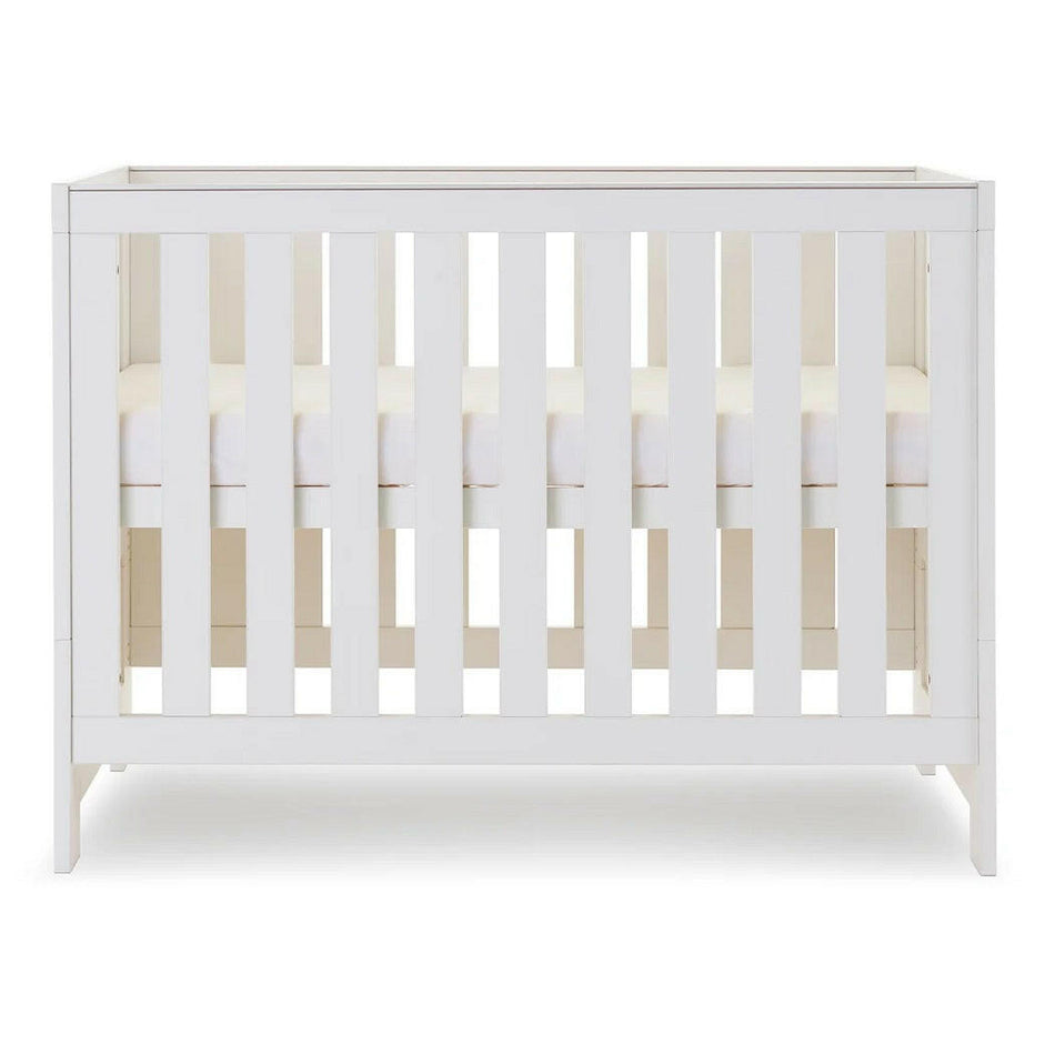 Obaby Nika MINI Cot Bed - White Wash side view, showing mattress base at highest level