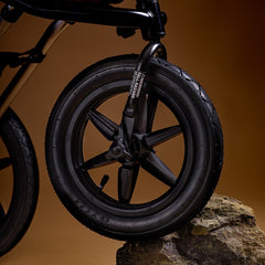 Mountain Buggy Terrain V4 Pushchair - front wheel sitting on a rock