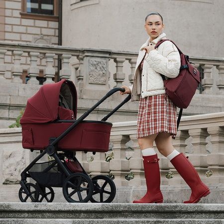 Hunter x Venicci Upline 3 Pram - Red - woman in red Hunter wellies with pram outdoors
