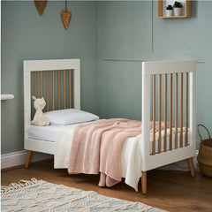 Obaby Maya Mini Cot Bed (White with Natural) - lifestyle image, shown here as  the junior bed (mattress and bedding not included, available separately)