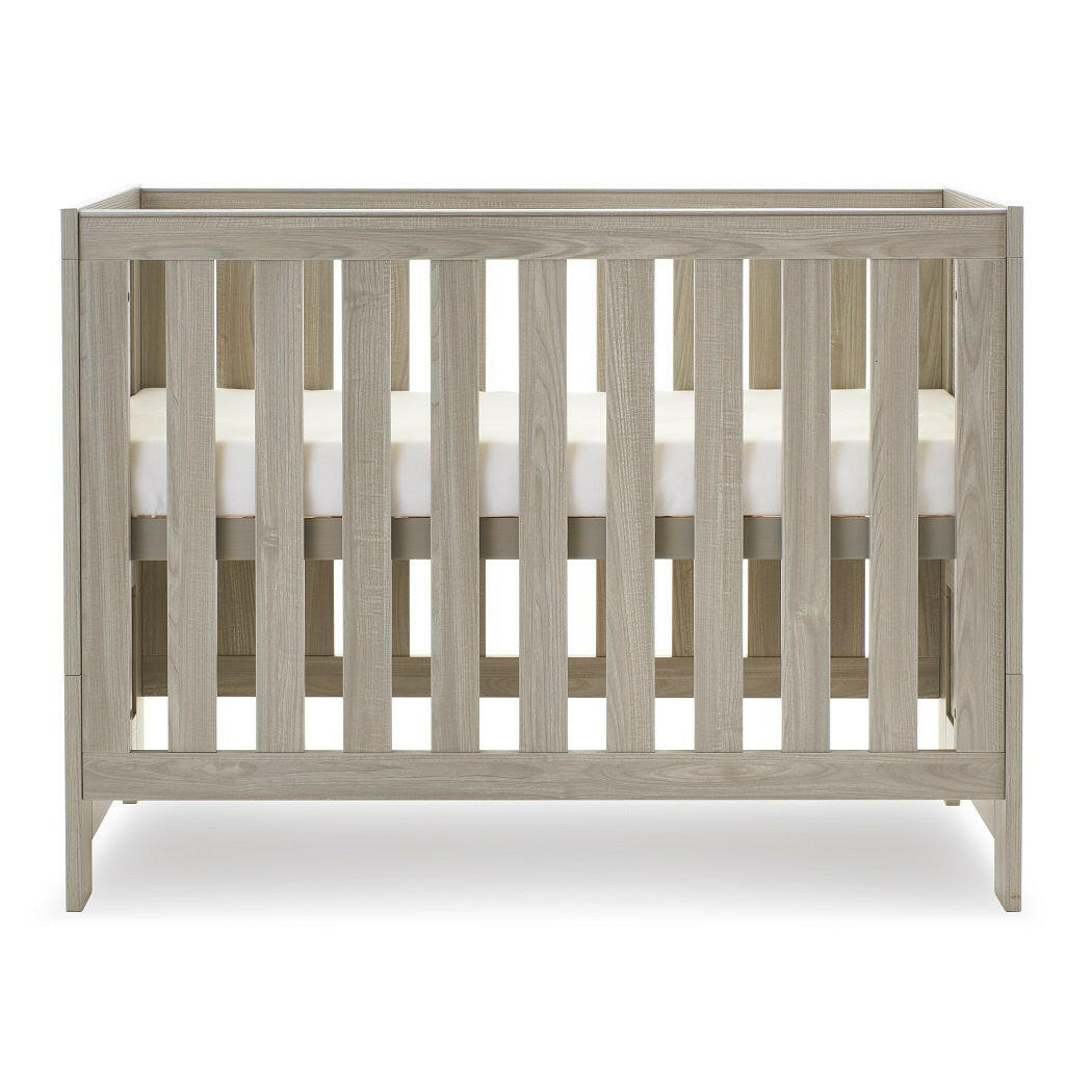 Obaby Nika Mini Cot Bed (Grey Wash) - side view, shown here with the mattress base at its highest level (mattress not included, available separately)