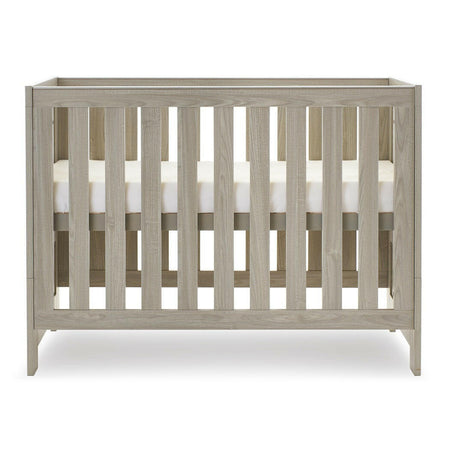 Obaby Nika Mini Cot Bed (Grey Wash) - side view, shown here with the mattress base at its highest level (mattress not included, available separately)