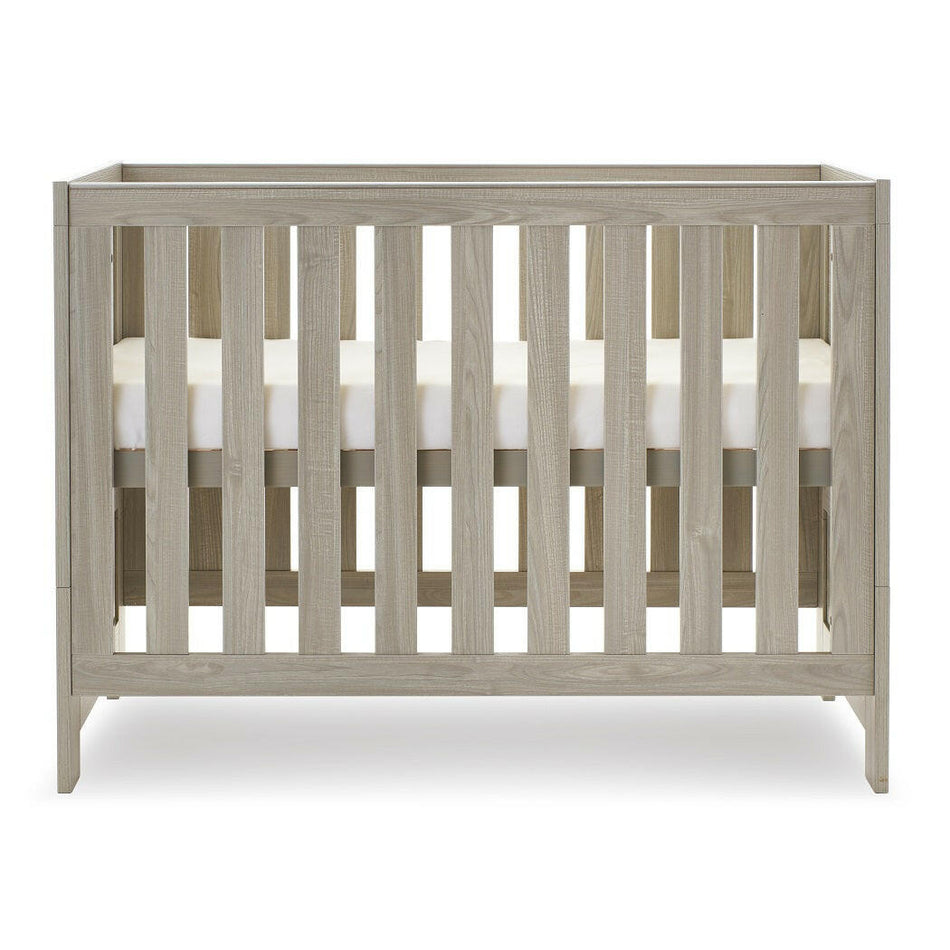 Obaby Nika Mini Cot Bed (Grey Wash) - side view, shown here with the mattress base at its highest level (mattress not included, available separately)