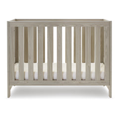 Obaby Nika Mini Cot Bed (Grey Wash) - side view, shown here with the mattress base at its lowest level (mattress not included, available separately)