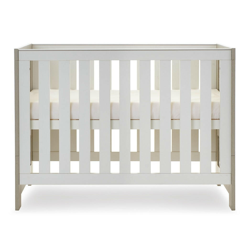 Obaby Nika Mini Cot Bed (Grey Wash & White) - side view, shown here with the mattress base at its highest level (mattress not included, available separately)