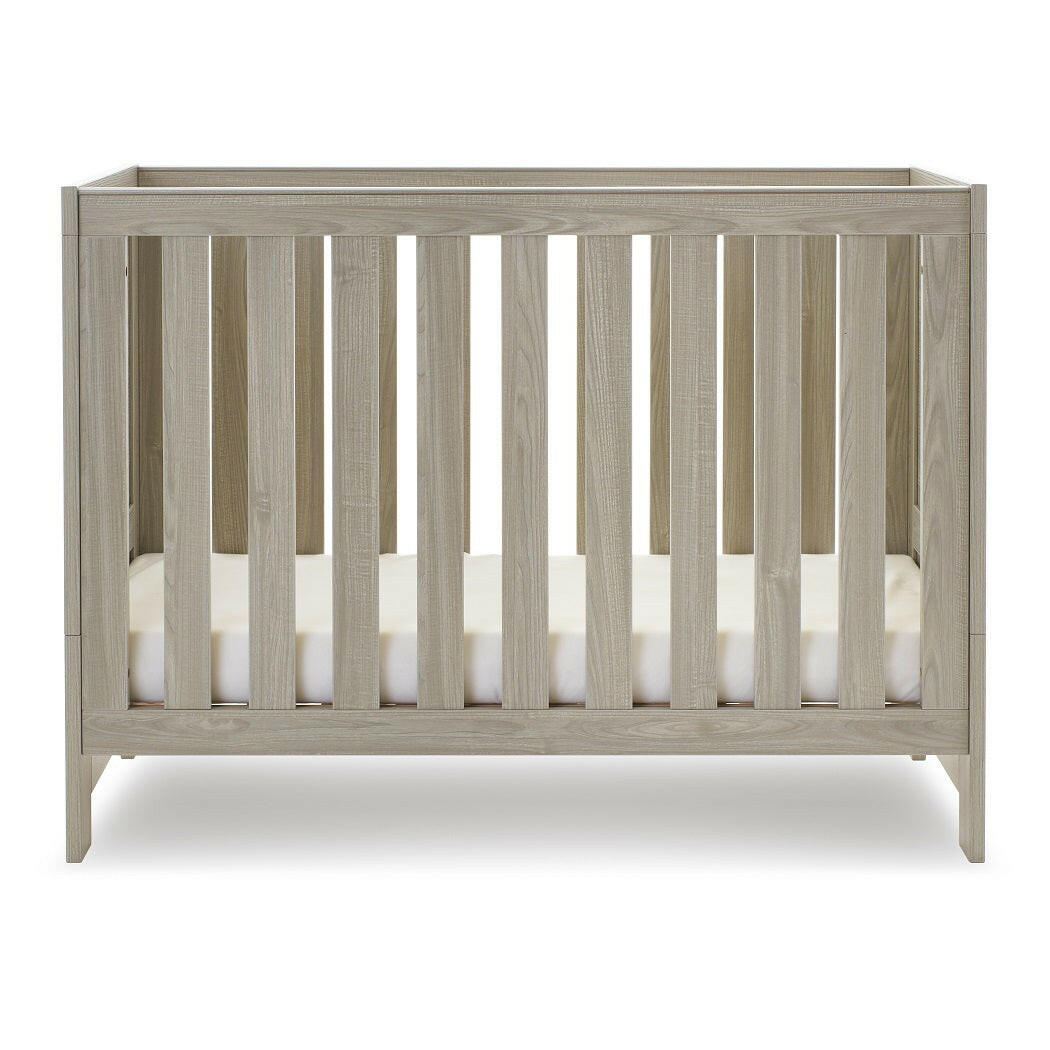 Obaby Nika Mini Cot Bed - Grey Wash - side view, with mattress base at lowest level