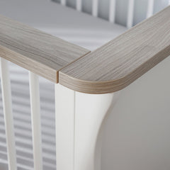 CuddleCo Clara Cot Bed (White & Ash) - lifestyle image, showing the driftwood ash accent