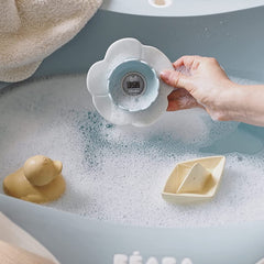 BEABA Lotus Bath and Room Thermometer (Green Blue) - lifestyle image, shown here being used in a bath