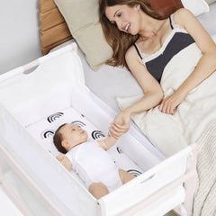SnuzPod⁴ Bedside Crib 3-in-1 (Rose White) - lifestyle image, showing the crib positioned next to parent`s bed