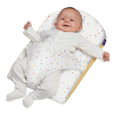 Clevamama ClevaFoam Reflux Wedge (White/Yellow) - showing an infant using the wedge whilst being safely held  in position