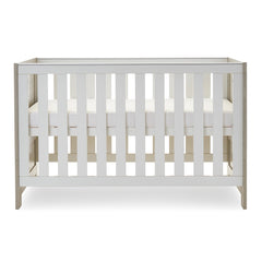 Obaby Nika Cot Bed (Grey Wash & White) - side view, shown here with the cot`s mattress base at its highest level (mattress not included, available separately)